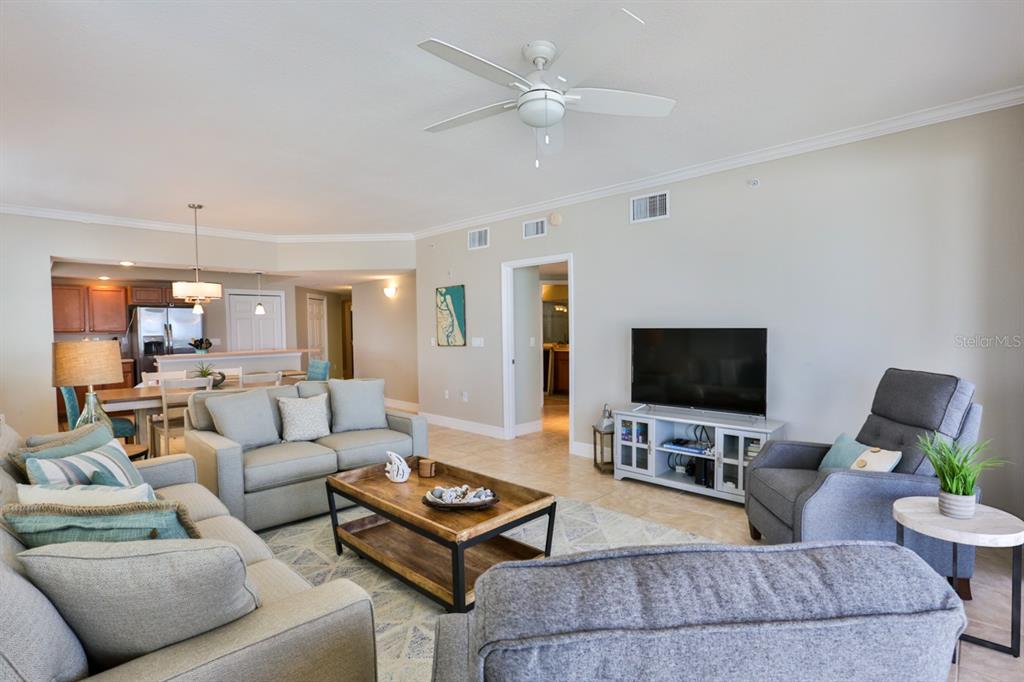 A living room with light gray furniture, a wooden coffee table, and a ceiling fan — 711 S ATLANTIC AVENUE UNIT 603, NEW SMYRNA BEACH, FL