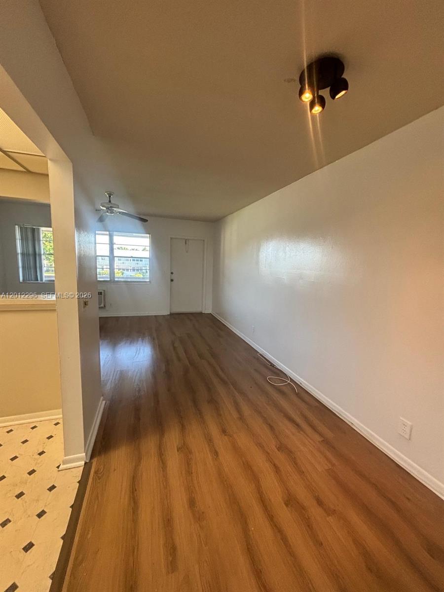 An interior view of a living area featuring wood-look flooring and a ceiling light fixture — WEST PALM BEACH, FL