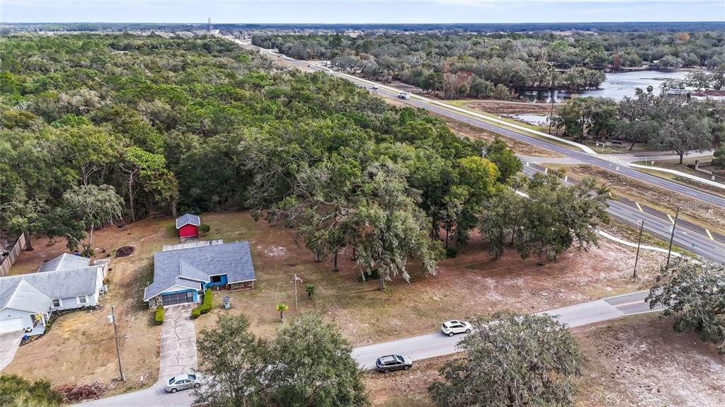 An aerial view shows a house with a red shed on a wooded lot — 5250 LITTLE GREEN LANE, DADE CITY, FL