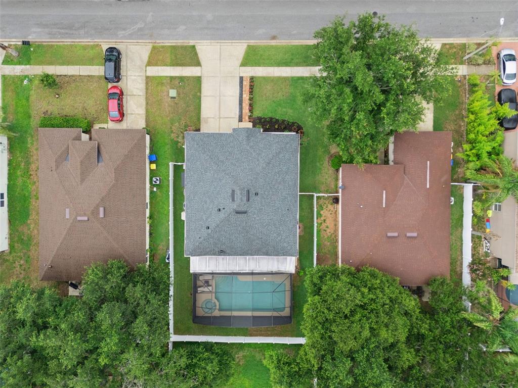 An aerial view shows three suburban houses with driveways, green lawns, and a screened pool — 2333 FOXTREE ROAD, TAVARES, FL