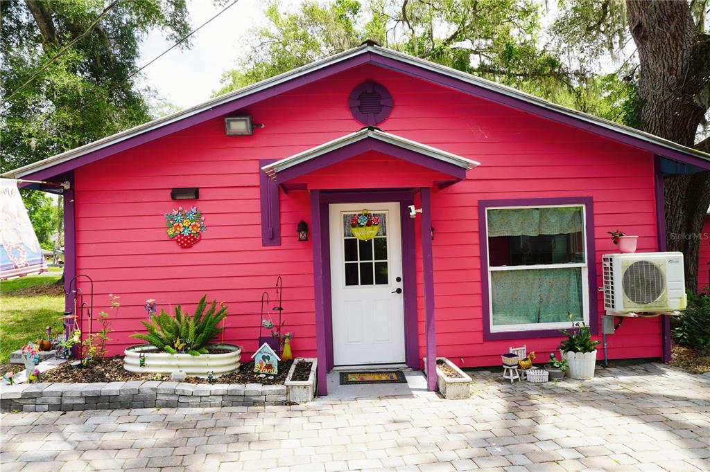 A bright pink house with purple trim, a white front door, and a paved patio — 11717 E SALMON DRIVE, FLORAL CITY, FL