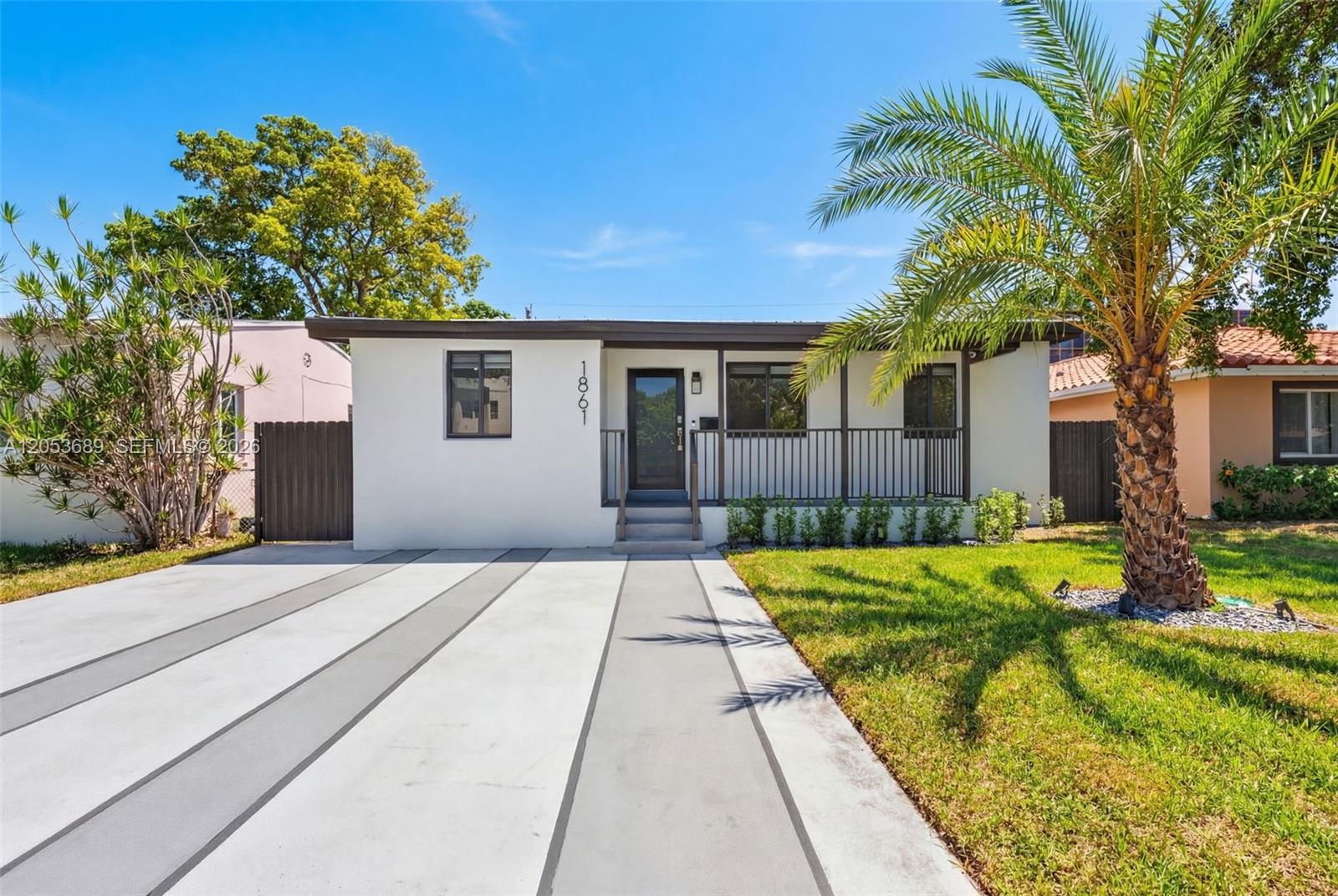 A single-story house with a white exterior, a front porch, and a concrete driveway — 1861 SW 22nd Ter, Miami FL 33145, MIAMI, FL