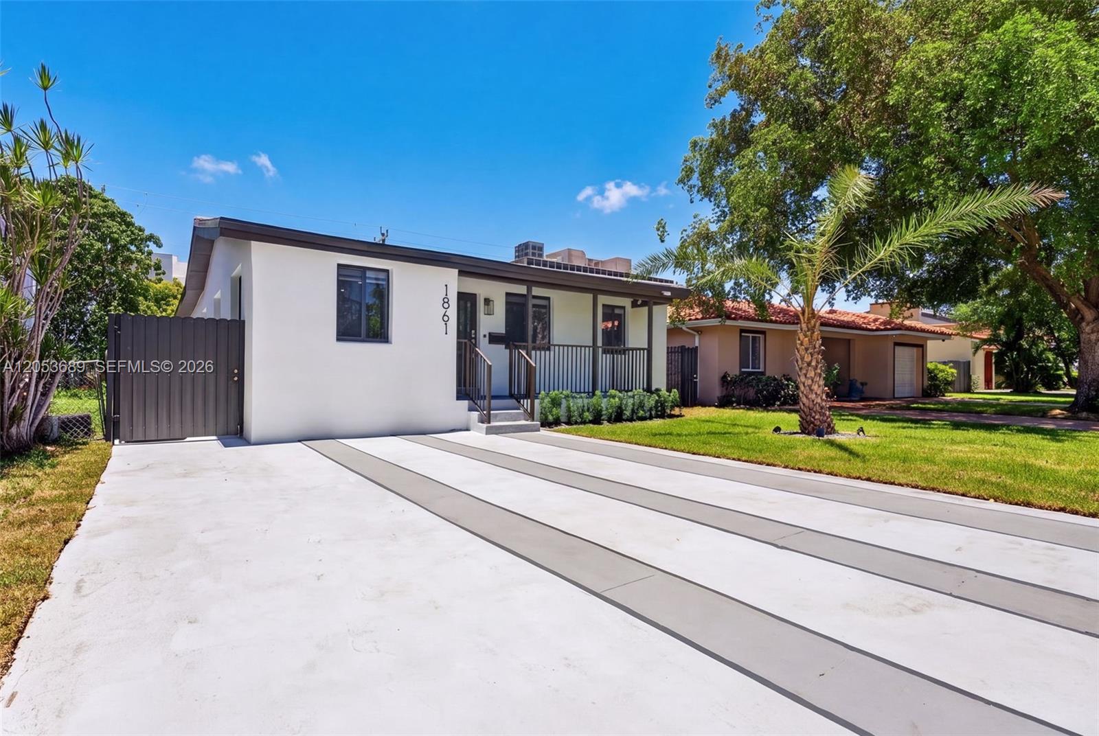 A single-story house with a white exterior, a concrete driveway, and a small front porch — 1861 SW 22nd Ter, Miami FL 33145, MIAMI, FL