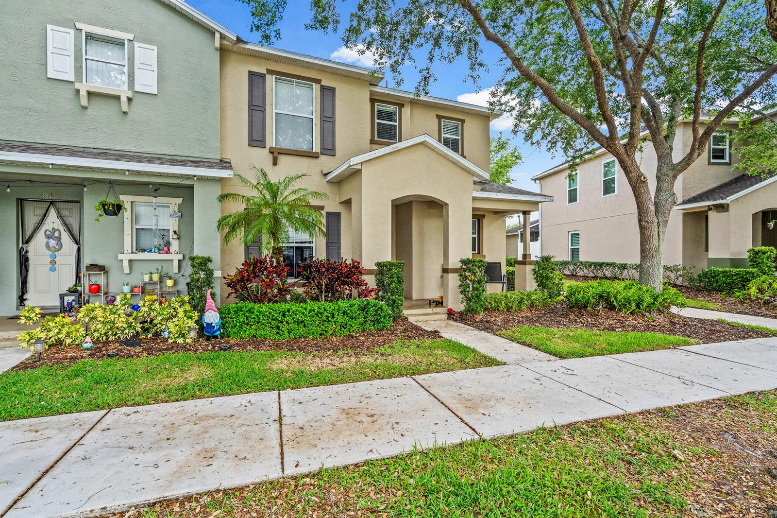 The exterior view shows two attached townhomes with tan and green stucco facades and landscaping — 1814 Pointe West Way, Vero Beach FL 32966, VERO BEACH, FL