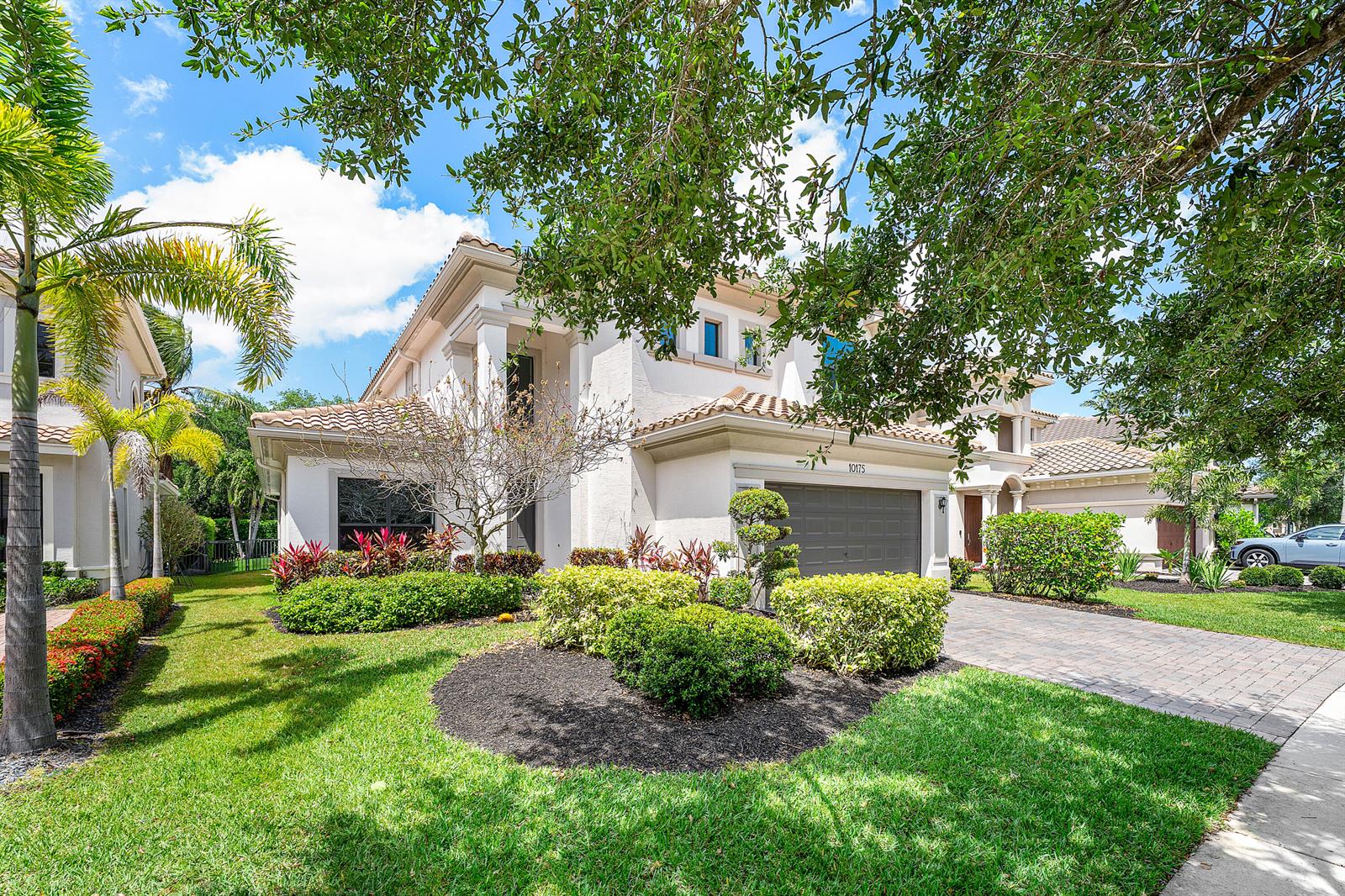 A two-story stucco house with a tile roof, a paved driveway, and landscaped front yard — 10175 Cameilla Street, Parkland FL 33076, PARKLAND, FL
