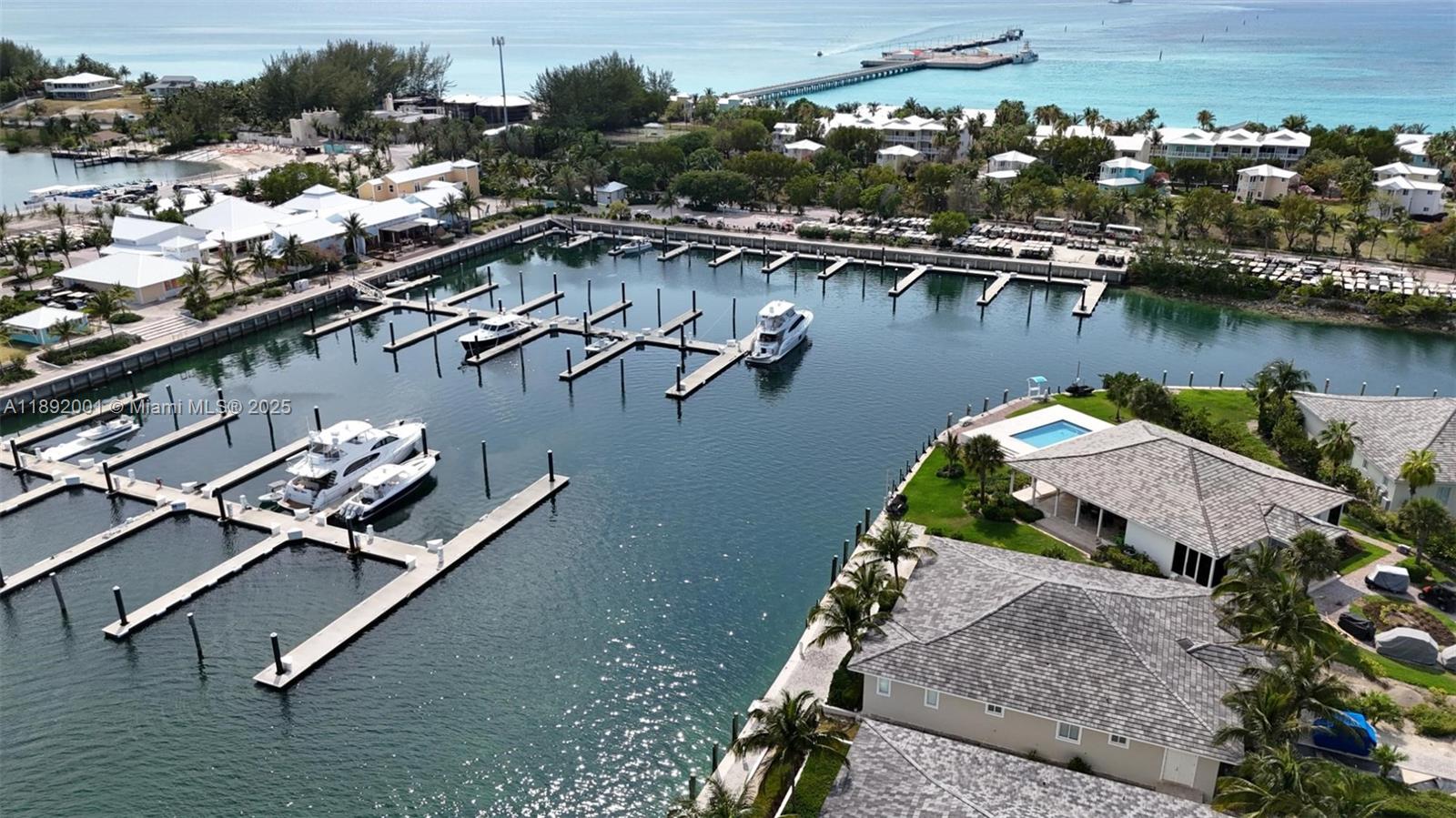 An aerial view shows a marina with docked boats and nearby waterfront residential buildings — Dolphin # 8 Fisherman Village Marina., ., .