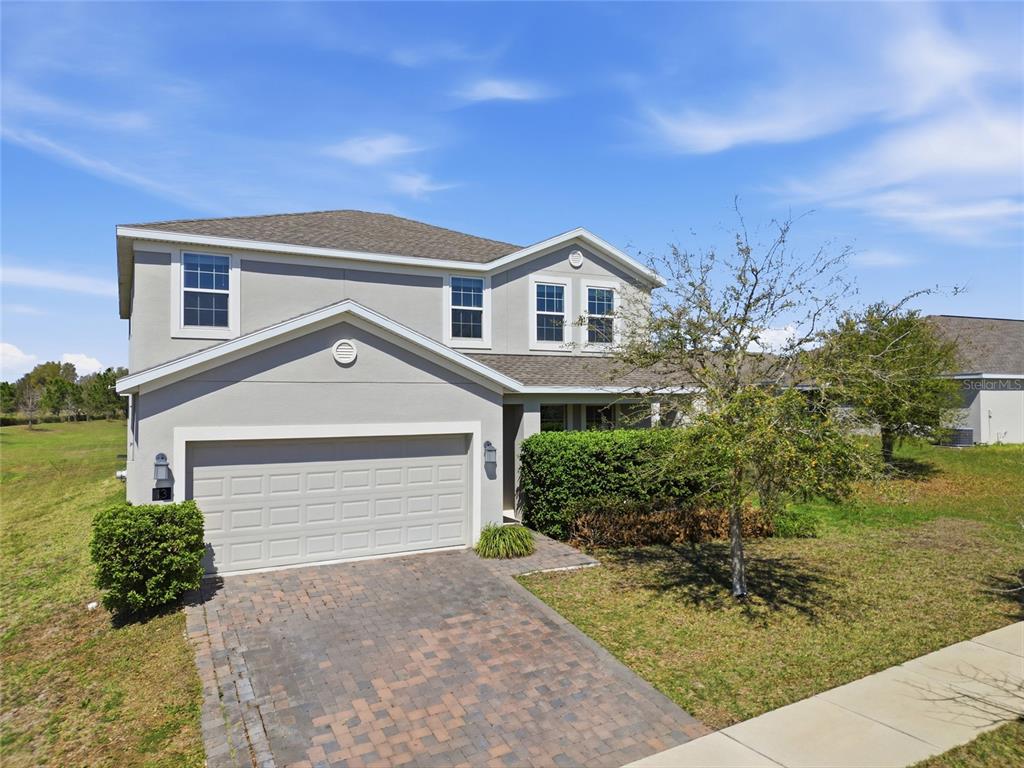 A two-story suburban house with a paved driveway, a two-car garage, and a front lawn — 13 WHITE HORSE WAY, GROVELAND, FL
