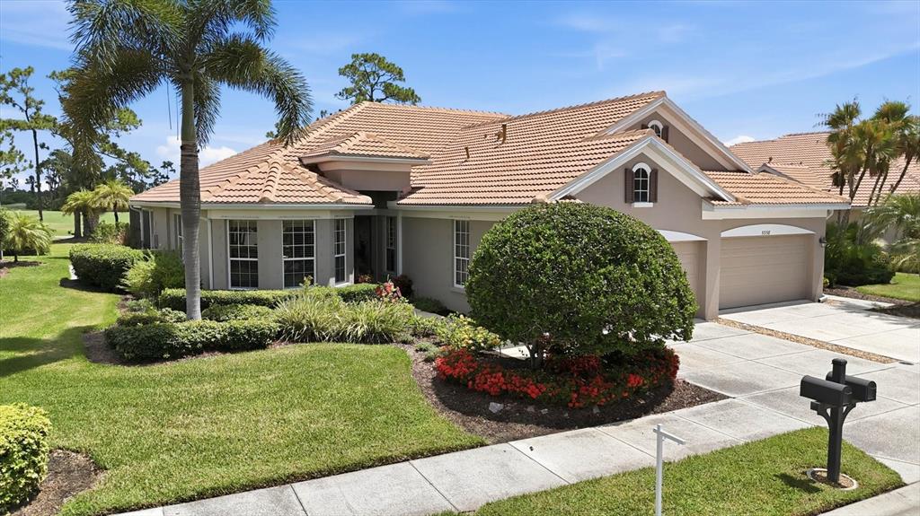 A single-story house with a tile roof, two-car garage, and landscaped front yard — 5364 WHITE IBIS DRIVE, NORTH PORT, FL