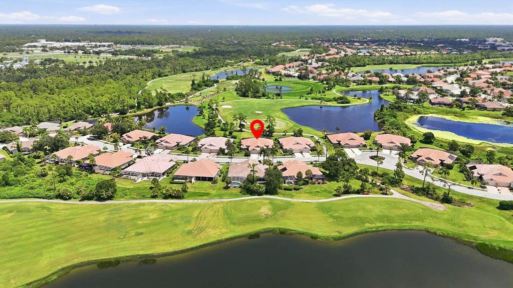 An aerial view shows a residential neighborhood with houses surrounding a golf course and lakes — 5364 WHITE IBIS DRIVE, NORTH PORT, FL