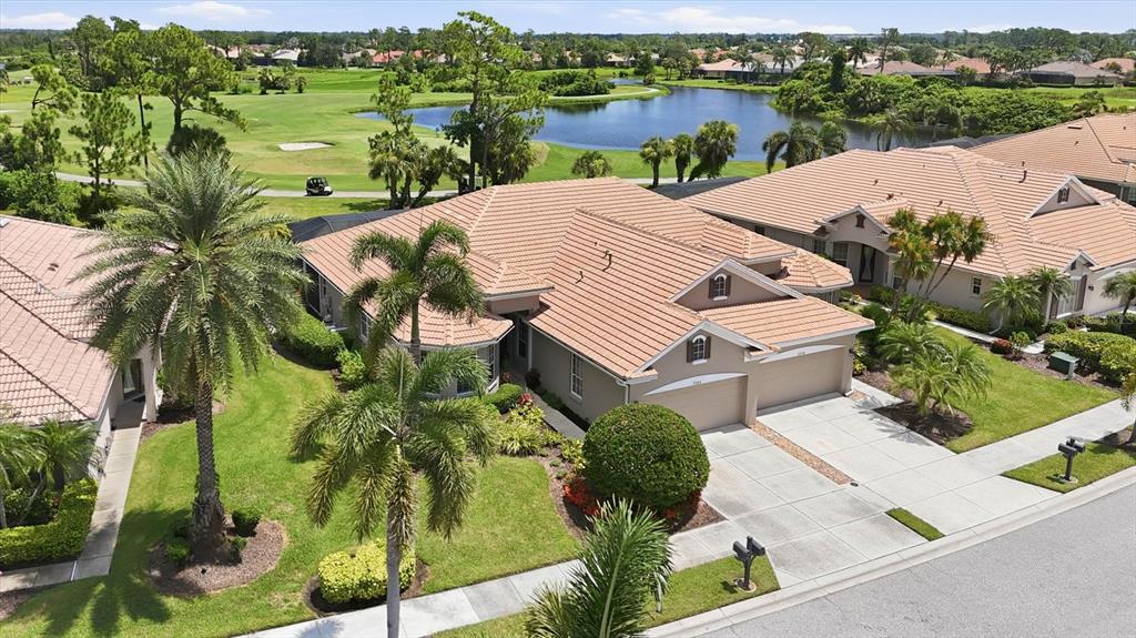 An aerial view of a suburban house with a tile roof overlooking a golf course — 5364 WHITE IBIS DRIVE, NORTH PORT, FL