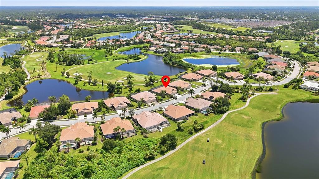 An aerial view shows a residential neighborhood with houses surrounding a golf course and lakes — 5364 WHITE IBIS DRIVE, NORTH PORT, FL