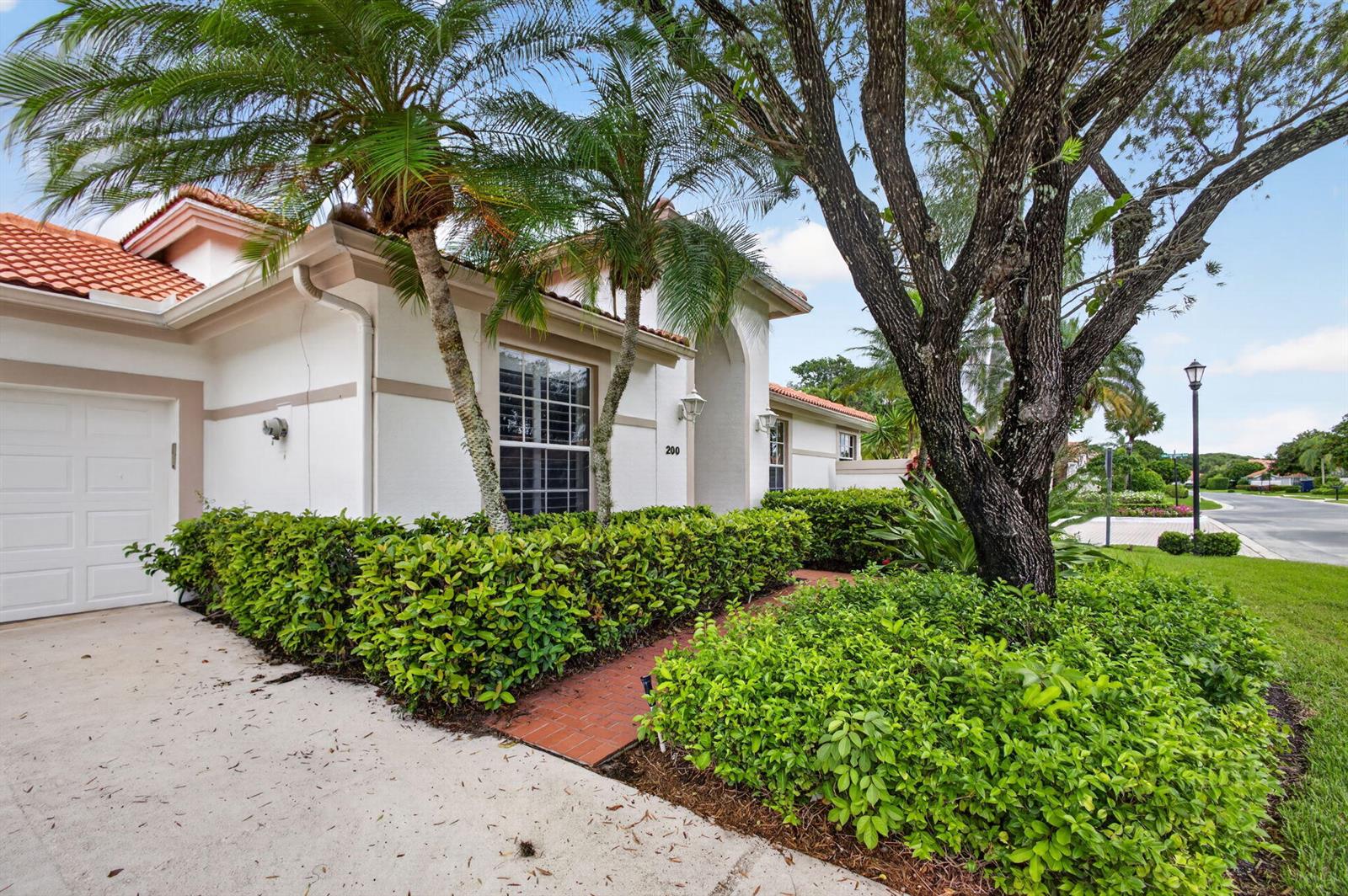A single-story house with a white exterior, red tile roof, and a brick walkway — 200 Eagleton Estates Boulevard, Palm Beach Gardens FL 33418, PALM BEACH GARDENS, FL