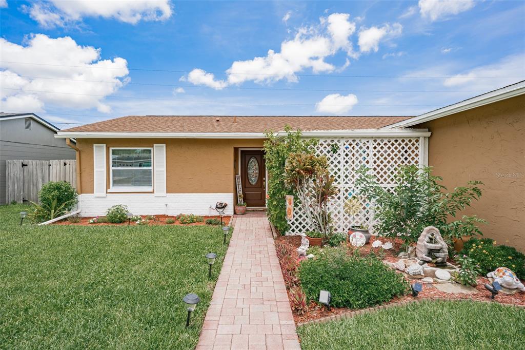 A single-story house with a brown exterior, white brick base, and a brick walkway — 6411 ELMHURST COURT, PINELLAS PARK, FL