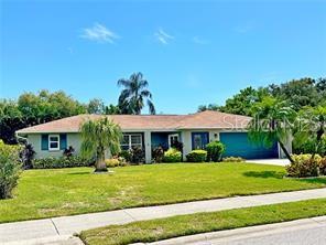 A single-story house with a tan roof, blue exterior walls, and palm trees in the yard — 4884 MARSH FIELD ROAD, SARASOTA, FL