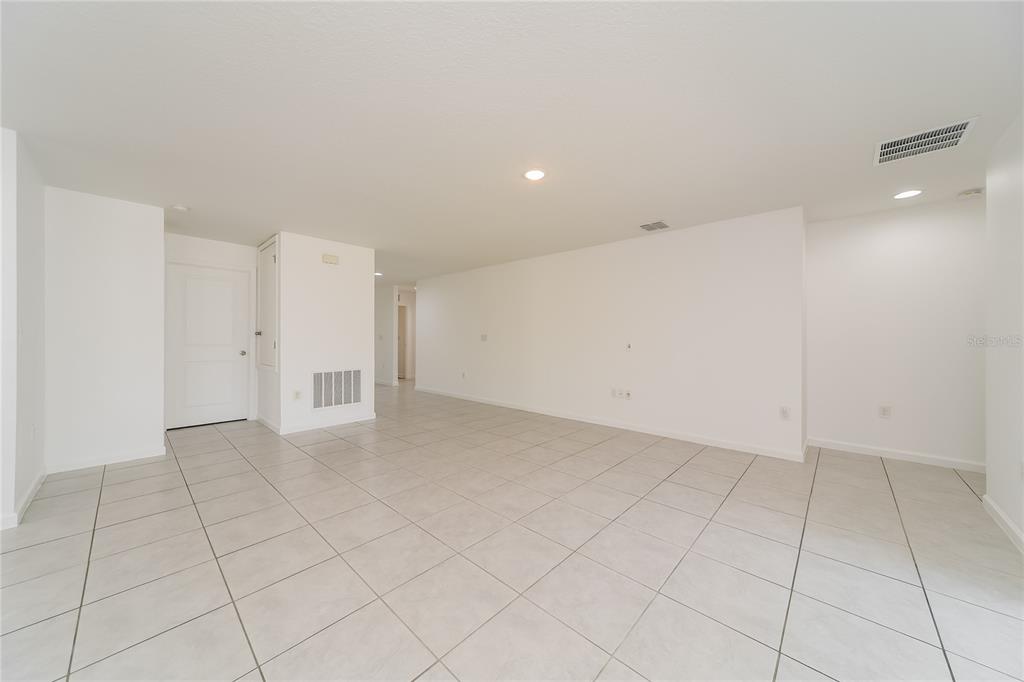 An empty room with white walls, recessed lighting, and light-colored tile flooring — 1373 LUCERNE LOOP ROAD NE, WINTER HAVEN, FL