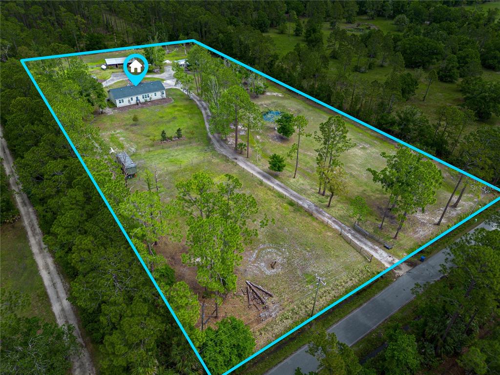 An aerial view shows a house on a large, fenced, wooded lot with a driveway — 3729 HONEY DEW LANE, NEW SMYRNA BEACH, FL