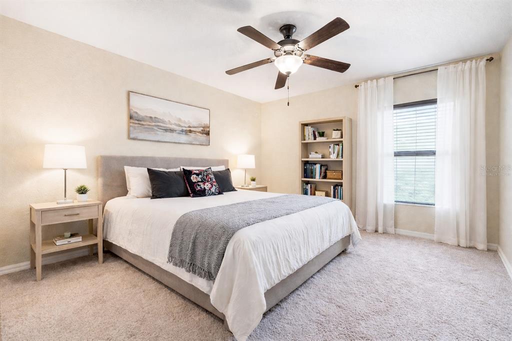A bedroom features a king bed, two nightstands, a bookshelf, and a ceiling fan — 1131 HIGHLAND MEADOWS STREET, DAVENPORT, FL