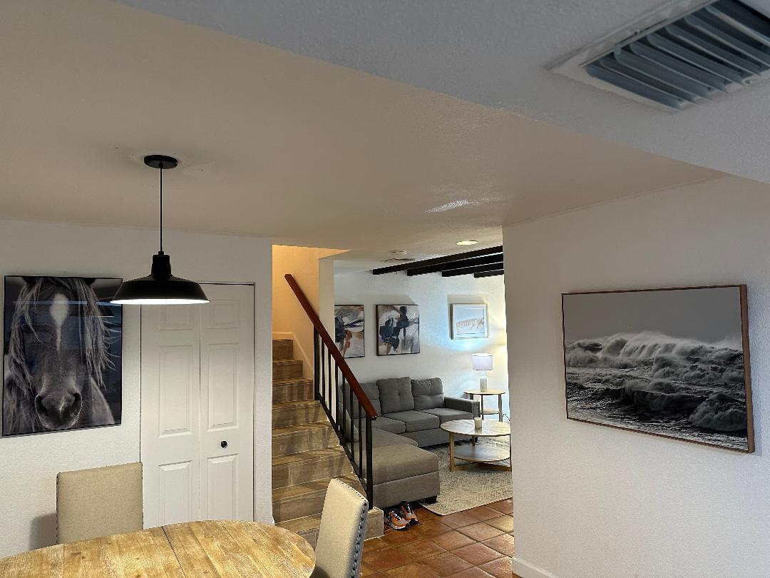 A dining area with a pendant light leads to a living room with stairs — 1608 Shaker Circle, Wellington FL 33414, WELLINGTON, FL