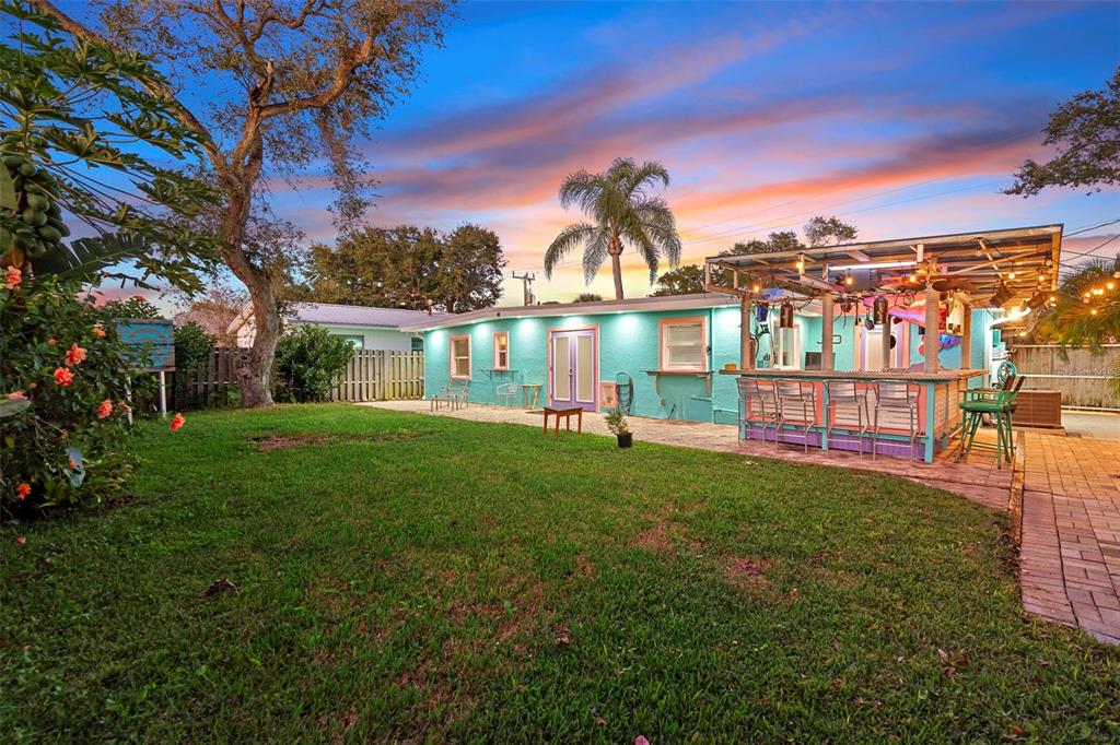 A turquoise house with a backyard patio and a covered outdoor bar at sunset — 650 S PINE STREET, NEW SMYRNA BEACH, FL