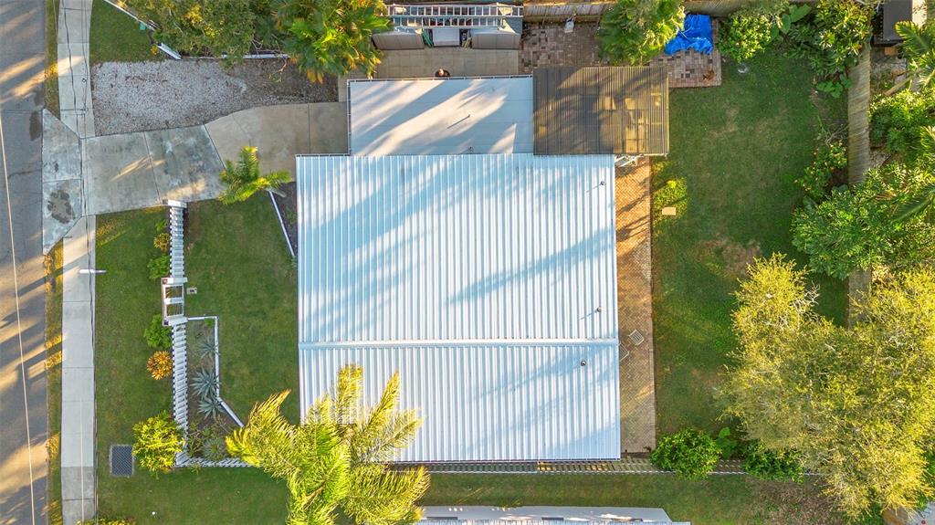 An aerial view shows a house with a metal roof, a driveway, and a backyard — 650 S PINE STREET, NEW SMYRNA BEACH, FL