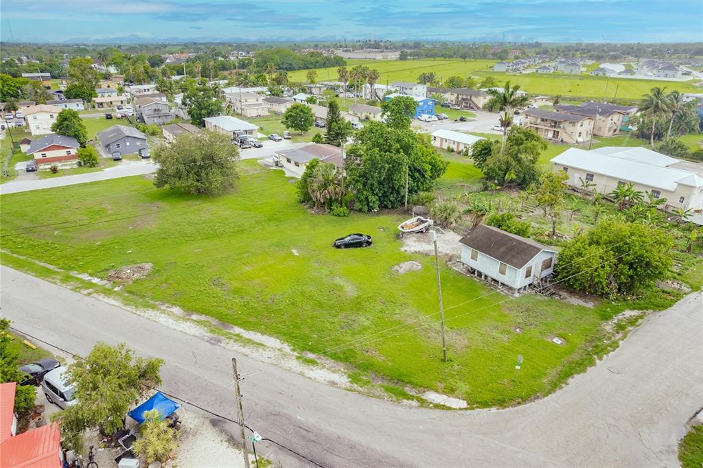 An aerial view shows a grassy lot with a small house, a car, and a boat — 601 SW 6TH STREET, BELLE GLADE, FL