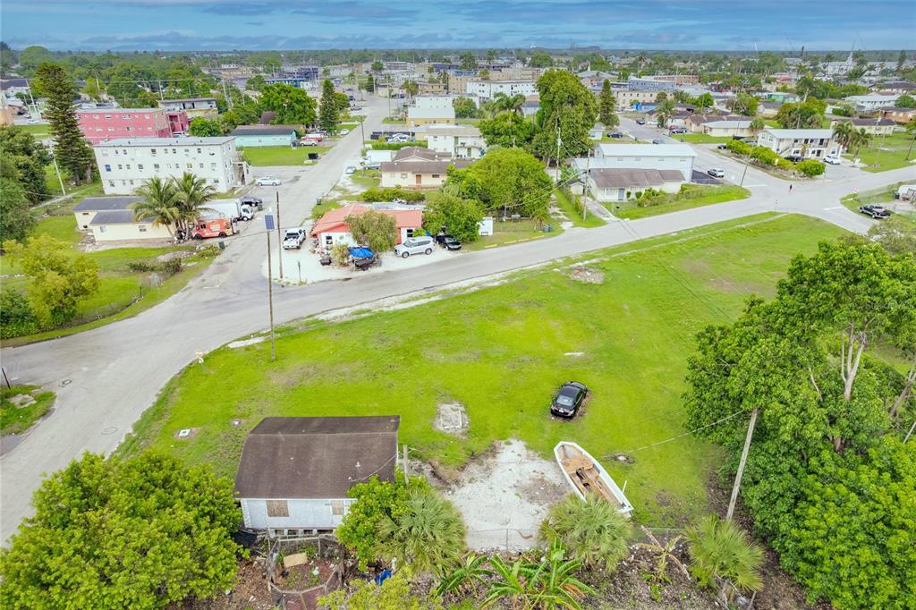 An aerial view shows a small house, a boat, and a car on a grassy lot — 601 SW 6TH STREET, BELLE GLADE, FL