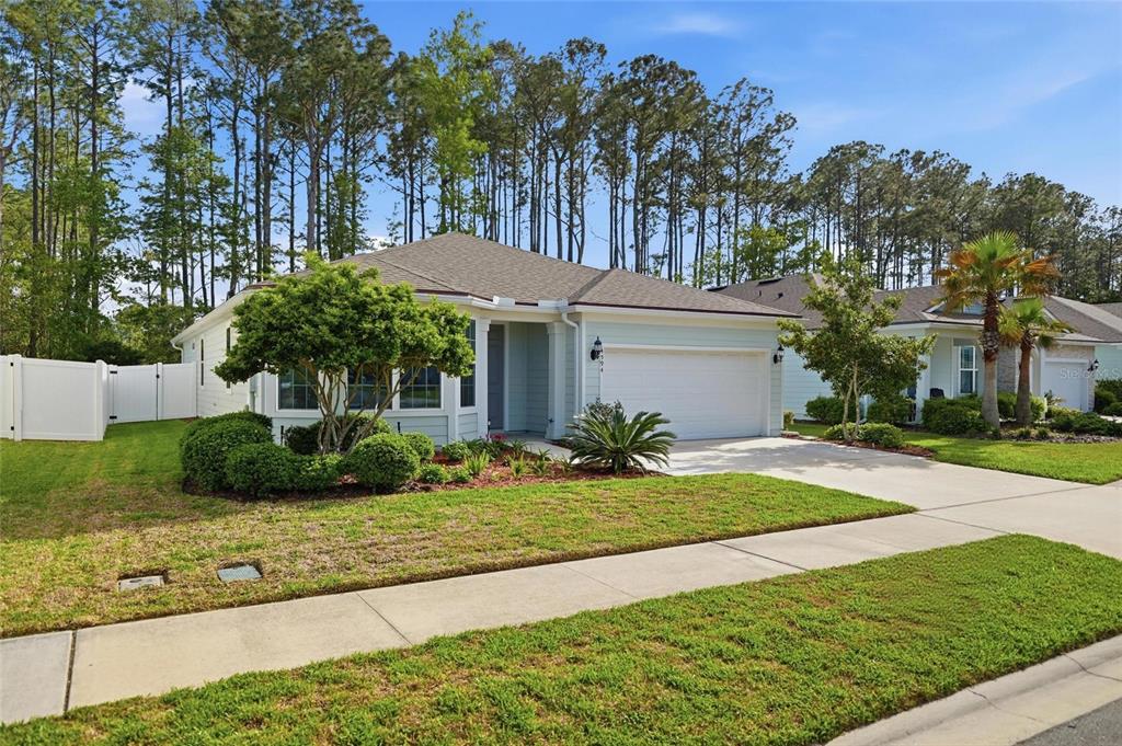 A light blue single-story house with a two-car garage and a landscaped front yard — 4594 FARMHOUSE GATE TRAIL, JACKSONVILLE, FL