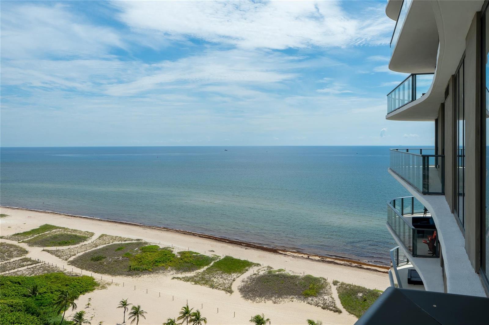 An elevated view of a sandy beach and ocean from a modern high-rise balcony — 730 N Ocean Boulevard, Pompano Beach FL 33062, POMPANO BEACH, FL
