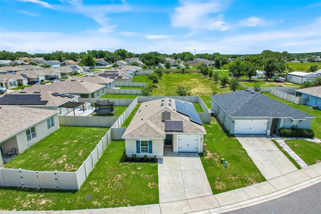 An aerial view shows a suburban house with solar panels and a fenced backyard — 479 JACKS WAY, DAVENPORT, FL