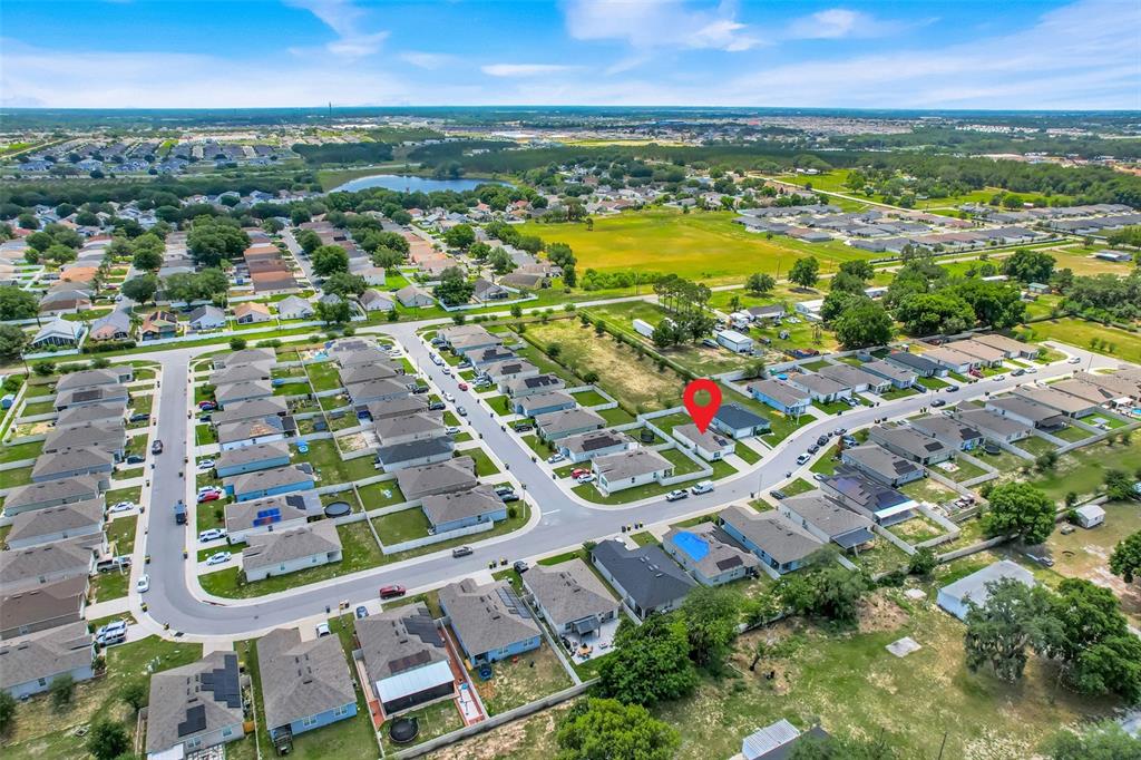 This aerial view shows a suburban neighborhood with single-family homes and a red location pin — 479 JACKS WAY, DAVENPORT, FL