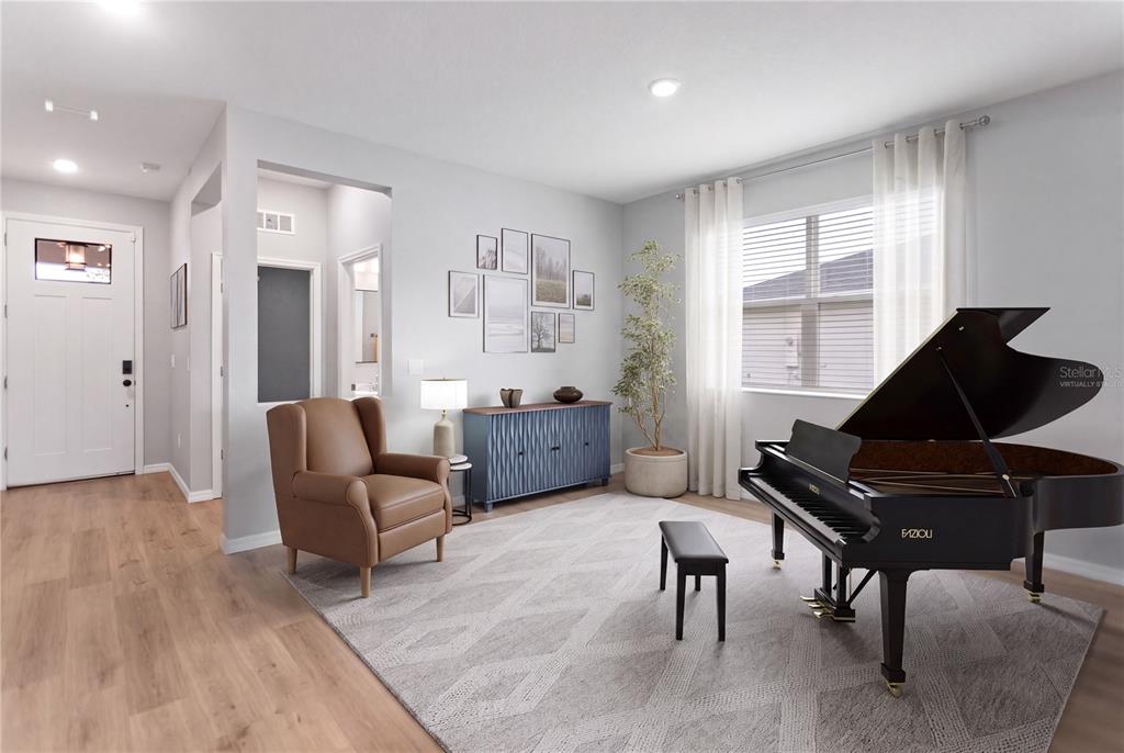 A living room features a grand piano, a brown armchair, and a blue sideboard — 12500 ASTON DRIVE, HUDSON, FL