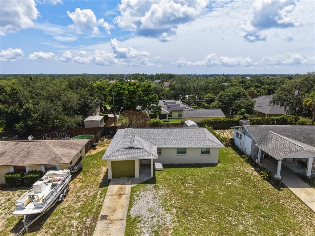 An aerial view shows a single-story house with a gray roof and a concrete driveway — 965 ALLENDALE STREET, TITUSVILLE, FL