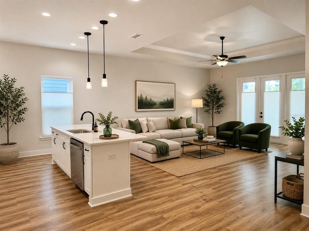 An open-concept living room and kitchen featuring a white island, sectional sofa, and green armchairs — 1186 NW 132ND BOULEVARD, NEWBERRY, FL