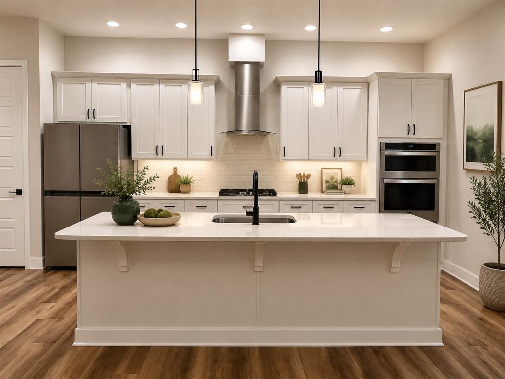 A modern kitchen features white cabinetry, stainless steel appliances, a large island, and wood flooring — 1186 NW 132ND BOULEVARD, NEWBERRY, FL