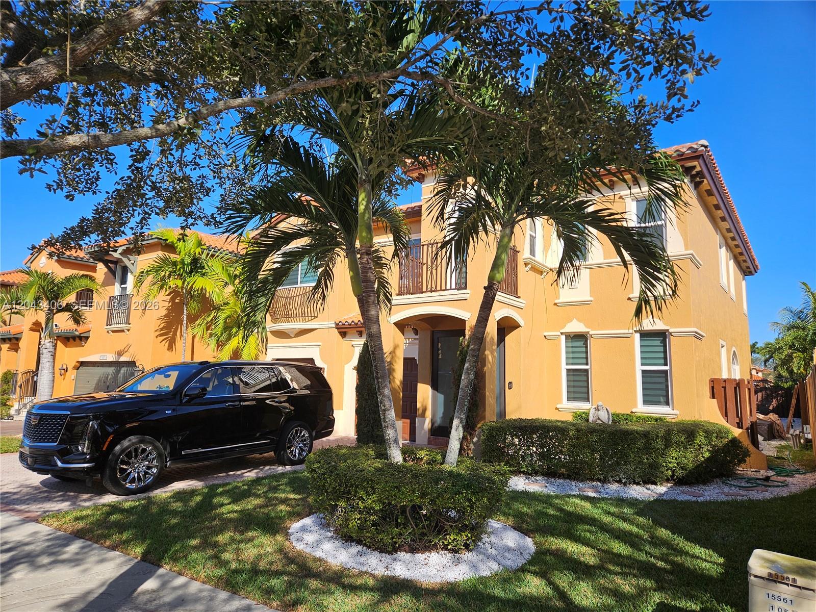 A two-story yellow stucco house with a black SUV parked in the driveway — 15561 SW 31st Ln # 0, Miami FL 33185, MIAMI, FL