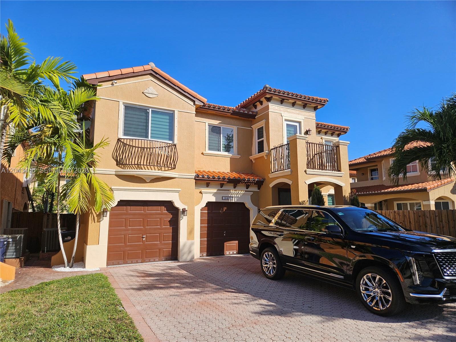 A two-story tan stucco house with a two-car garage and a black SUV parked outside — 15561 SW 31st Ln # 0, Miami FL 33185, MIAMI, FL