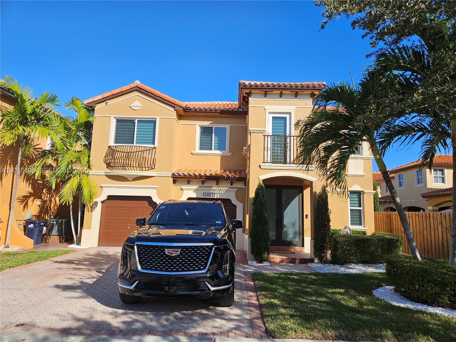 A two-story tan stucco house with a tile roof and a black SUV parked in front — 15561 SW 31st Ln # 0, Miami FL 33185, MIAMI, FL