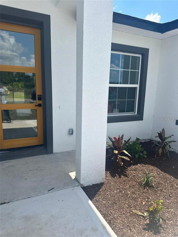 The exterior view shows a wooden front door next to a window and landscaping — 5842 SW 154TH LANE ROAD, OCALA, FL