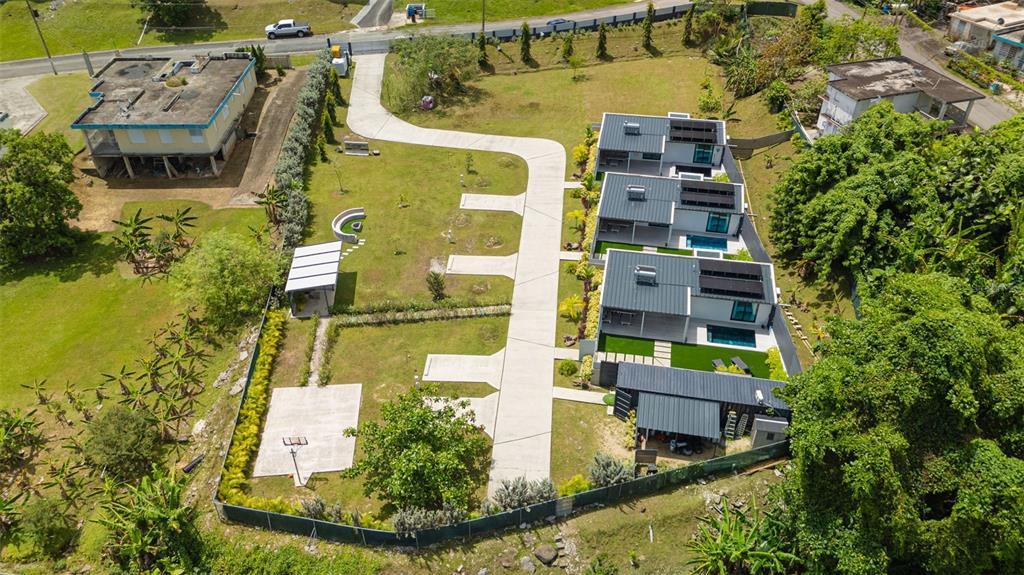 An aerial view shows a modern residential complex with three houses, pools, and paved walkways — PR-967 BO JIMENEZ KM. 1.5, RIO GRANDE, PR
