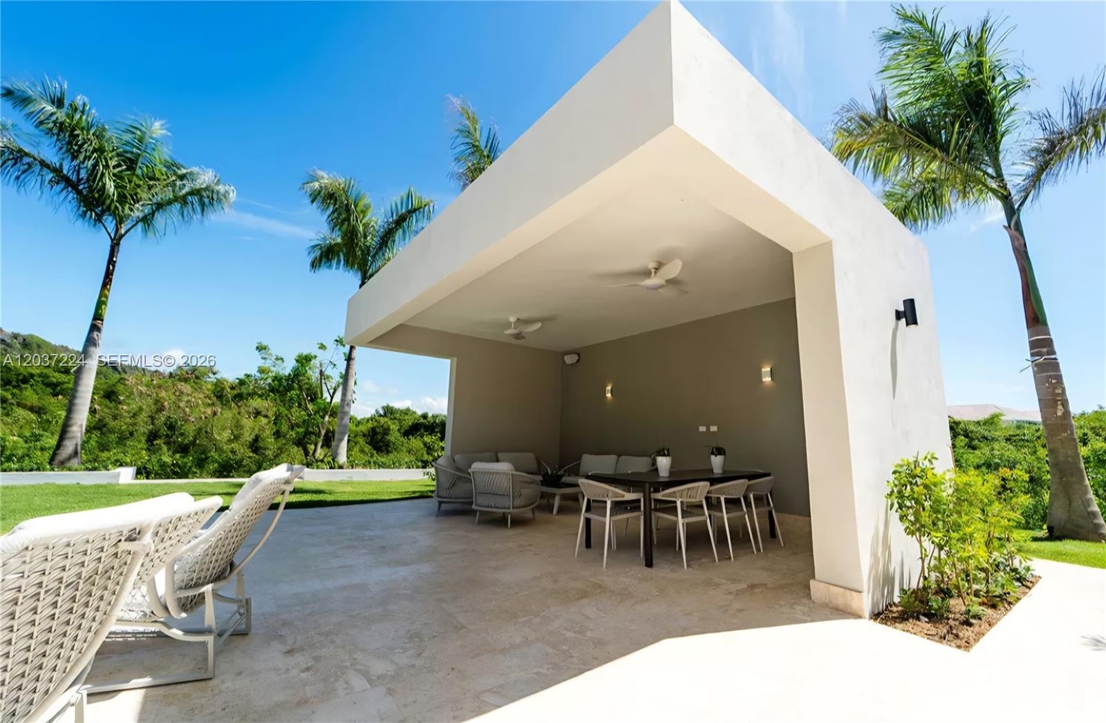 A modern outdoor covered patio features a dining set, lounge seating, and palm trees — 0 Farralon, FL