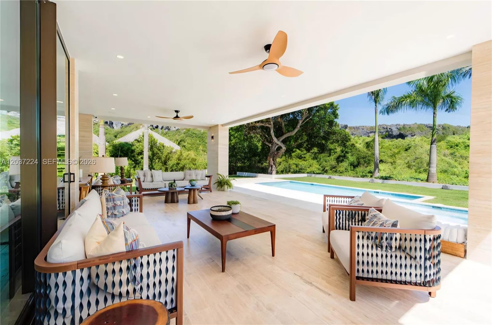 An outdoor covered patio features modern furniture, ceiling fans, and a view of a swimming pool — 0 Farralon, FL