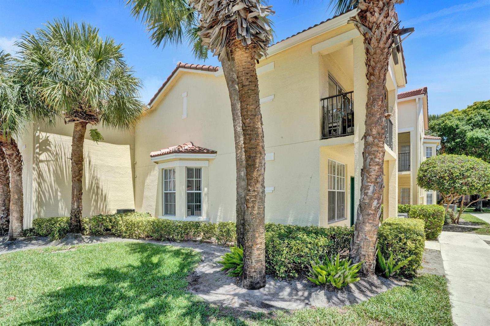 A two-story stucco apartment building with palm trees, a balcony, and a bay window — 708 Belmont Place, Boynton Beach FL 33436, BOYNTON BEACH, FL