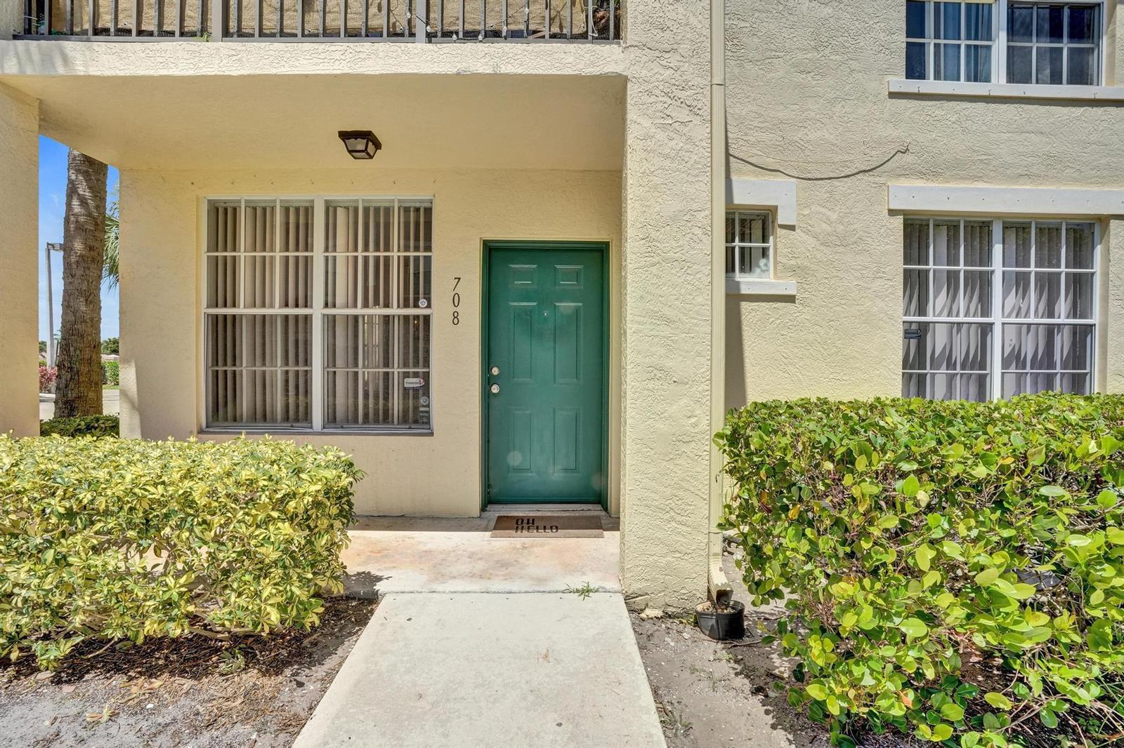 A green front door with the number 708 sits at the entrance of a beige building — 708 Belmont Place, Boynton Beach FL 33436, BOYNTON BEACH, FL