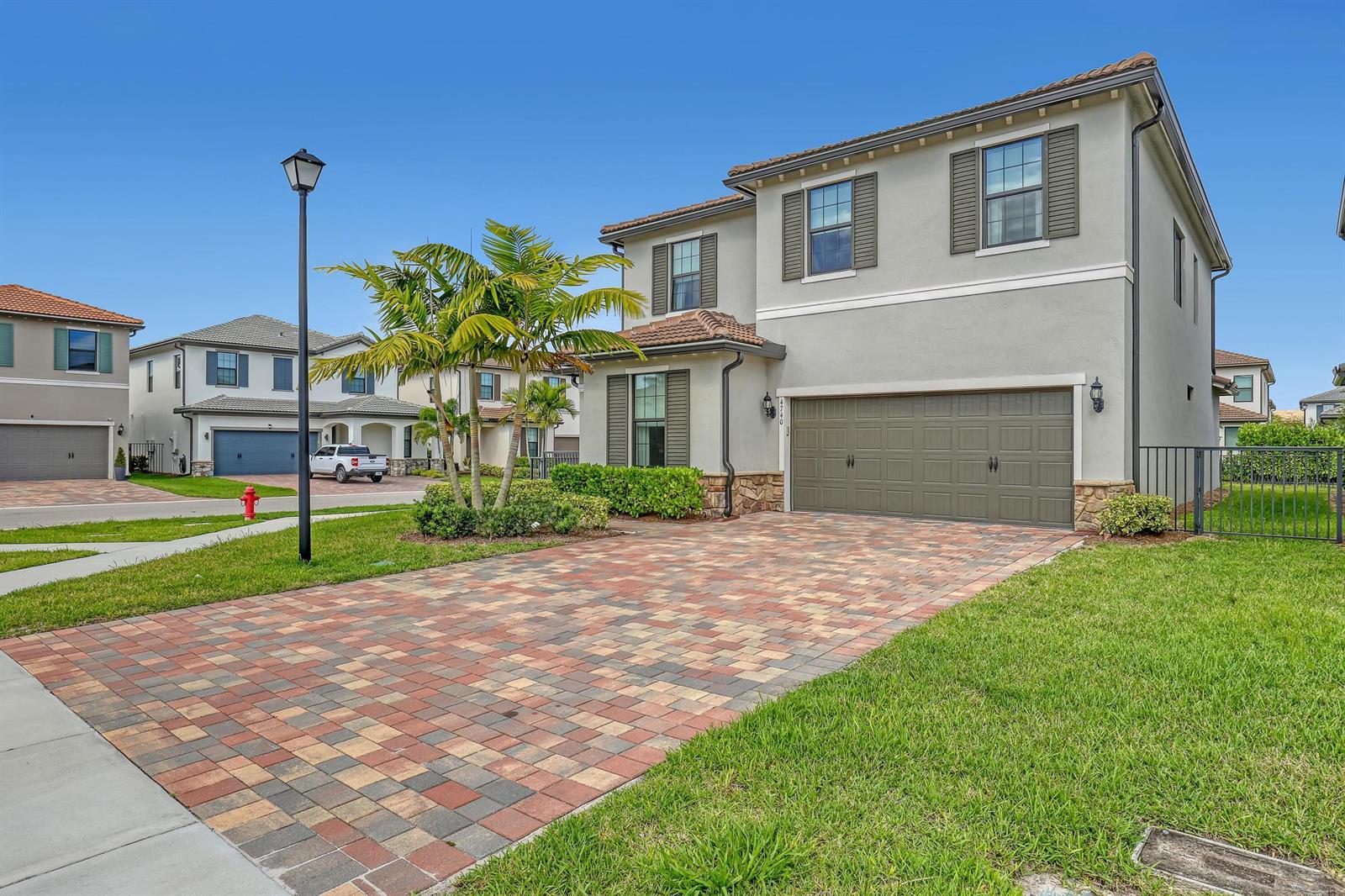 A two-story suburban house features a paved driveway, a two-car garage, and a palm tree — 4740 Chantilly, Lake Worth FL 33467, LAKE WORTH, FL