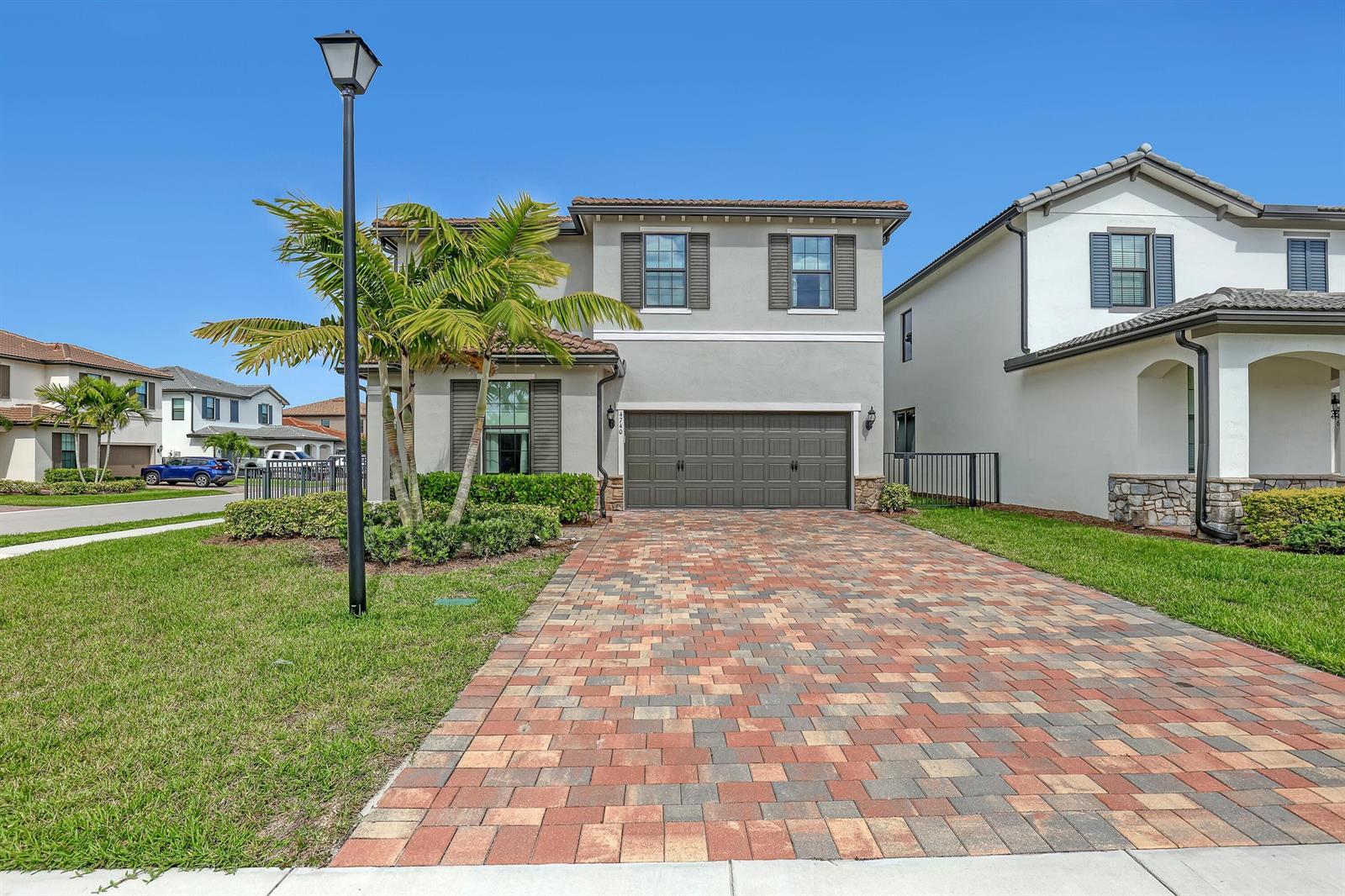 A two-story house with a paved driveway, a palm tree, and a two-car garage — 4740 Chantilly, Lake Worth FL 33467, LAKE WORTH, FL