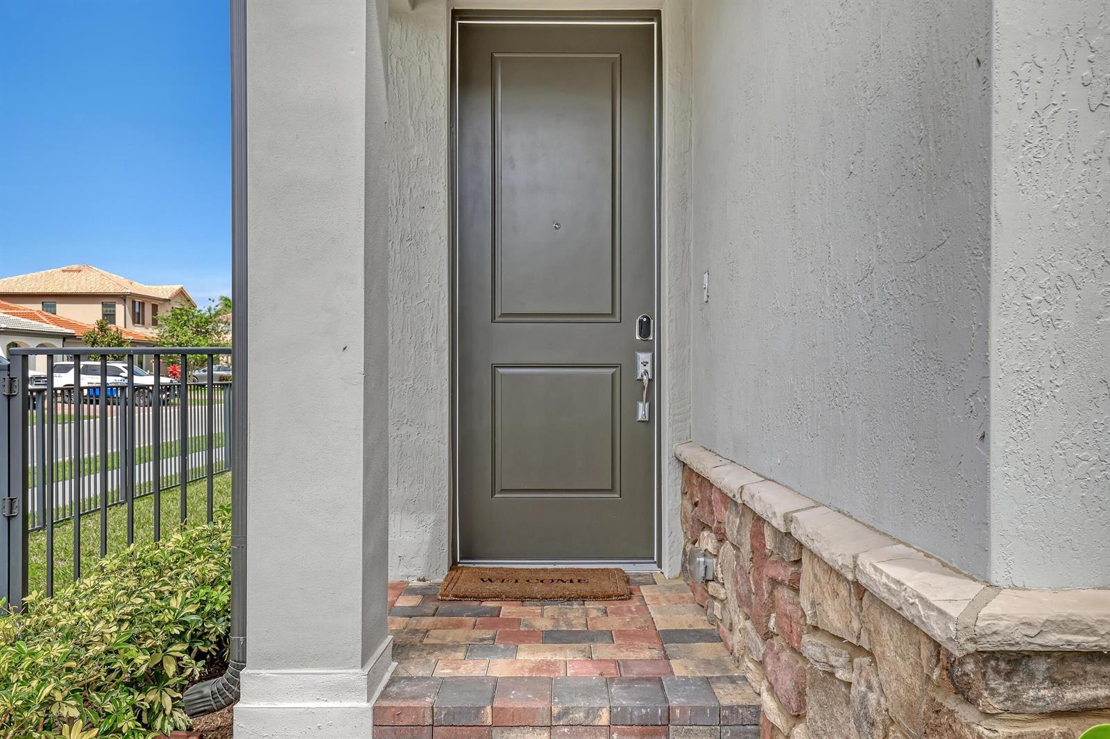 A front entryway features a dark brown door, stone veneer siding, and brick paver steps — 4740 Chantilly, Lake Worth FL 33467, LAKE WORTH, FL