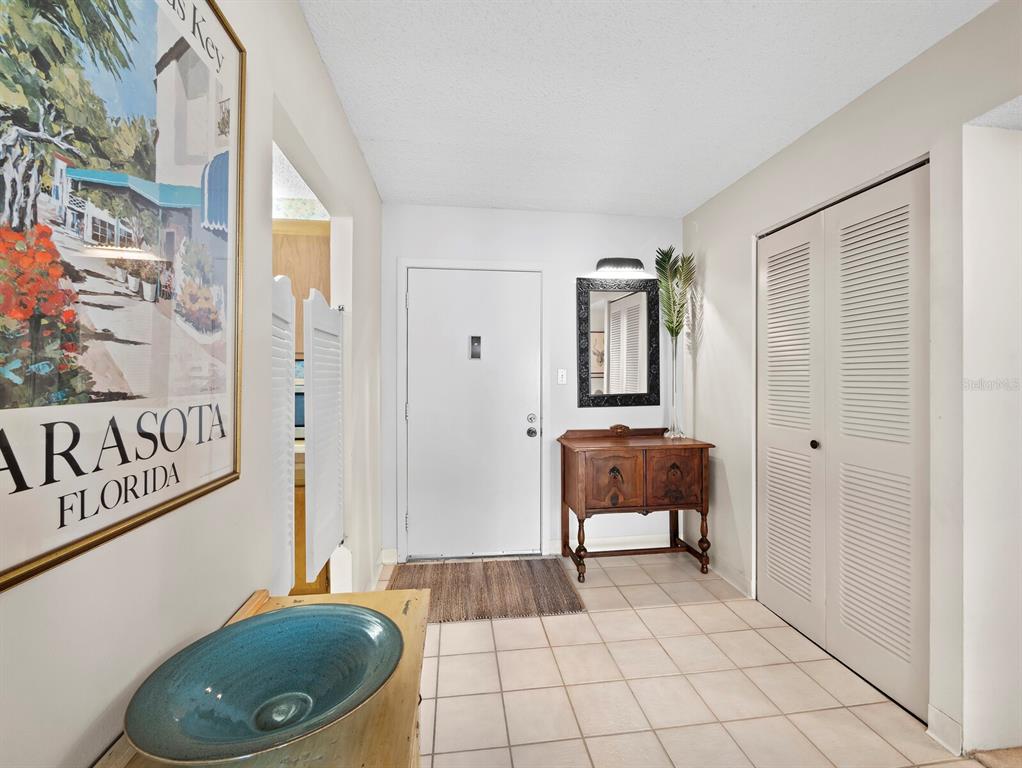 An entryway features a tiled floor, a white front door, a wooden console, and closets — 5055 GULF OF MEXICO DRIVE UNIT 421, LONGBOAT KEY, FL
