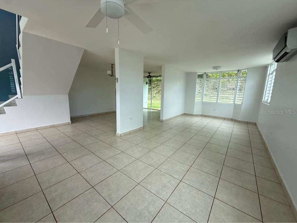 An open-concept living area features light-colored tile flooring, white walls, and large windows — 15 CALLE MARINA, CABO ROJO, PR