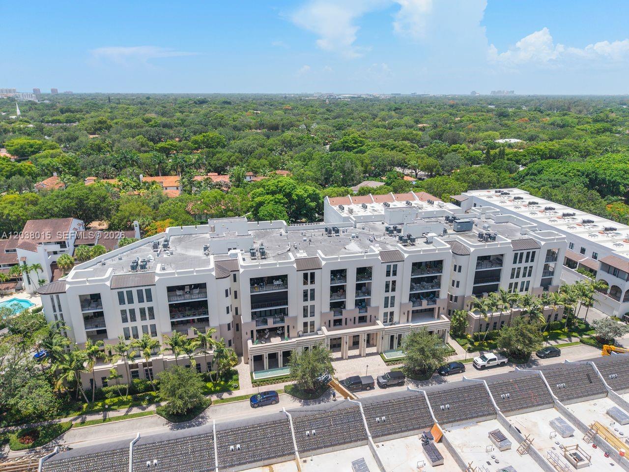 An aerial view shows a multi-story apartment building surrounded by trees and parking areas — 718 Valencia Ave # 403, Coral Gables FL 33134, CORAL GABLES, FL