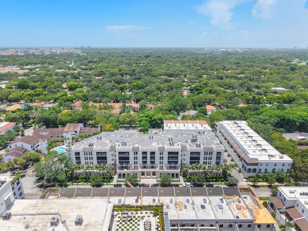 An aerial view shows a multi-story residential building surrounded by trees and suburban homes — 718 Valencia Ave # 403, Coral Gables FL 33134, CORAL GABLES, FL